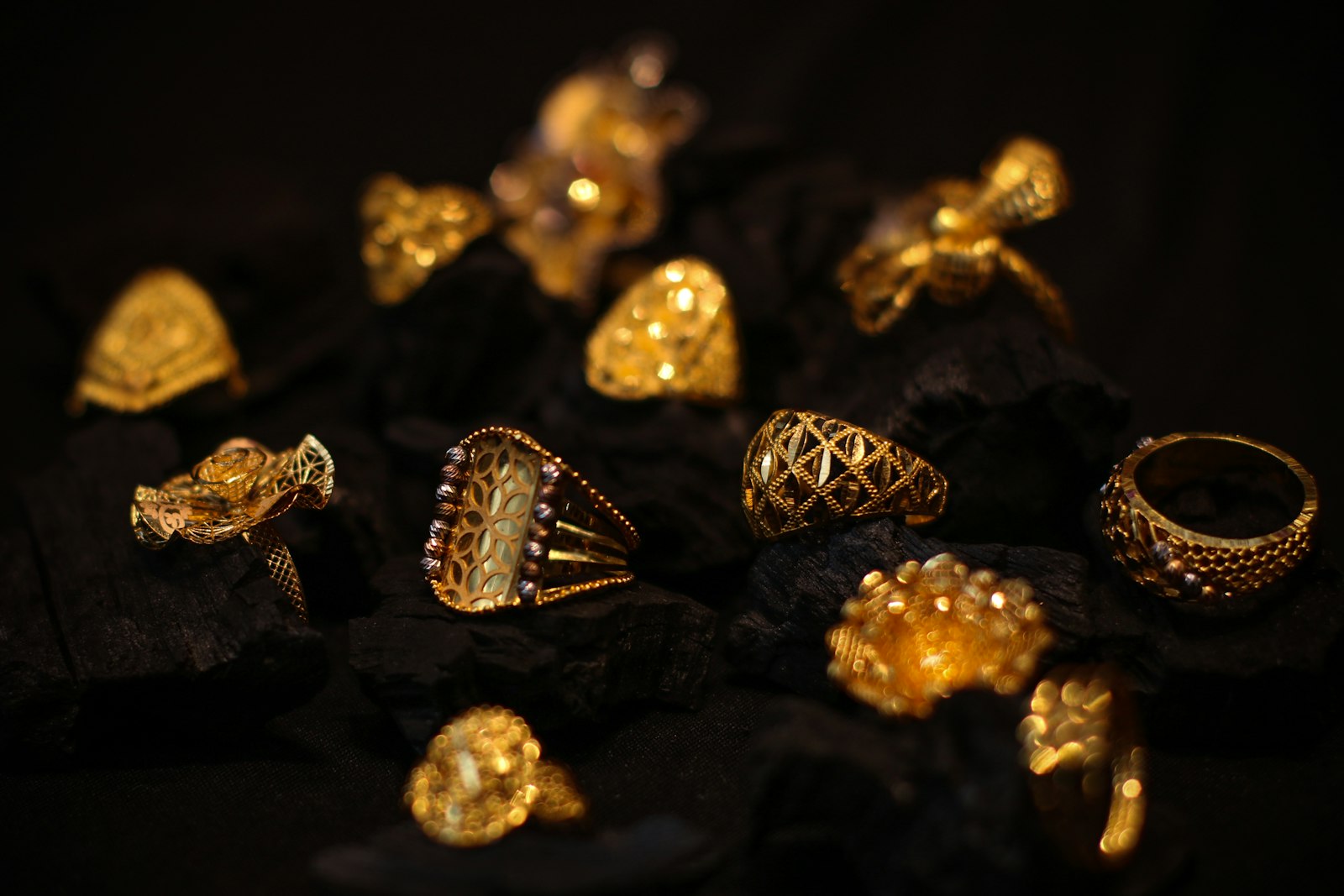 Ornate gold rings on dark charcoal