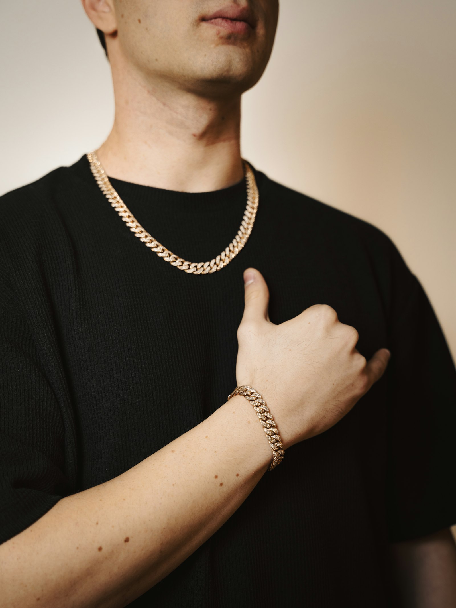 Man wearing a gold chain and bracelet