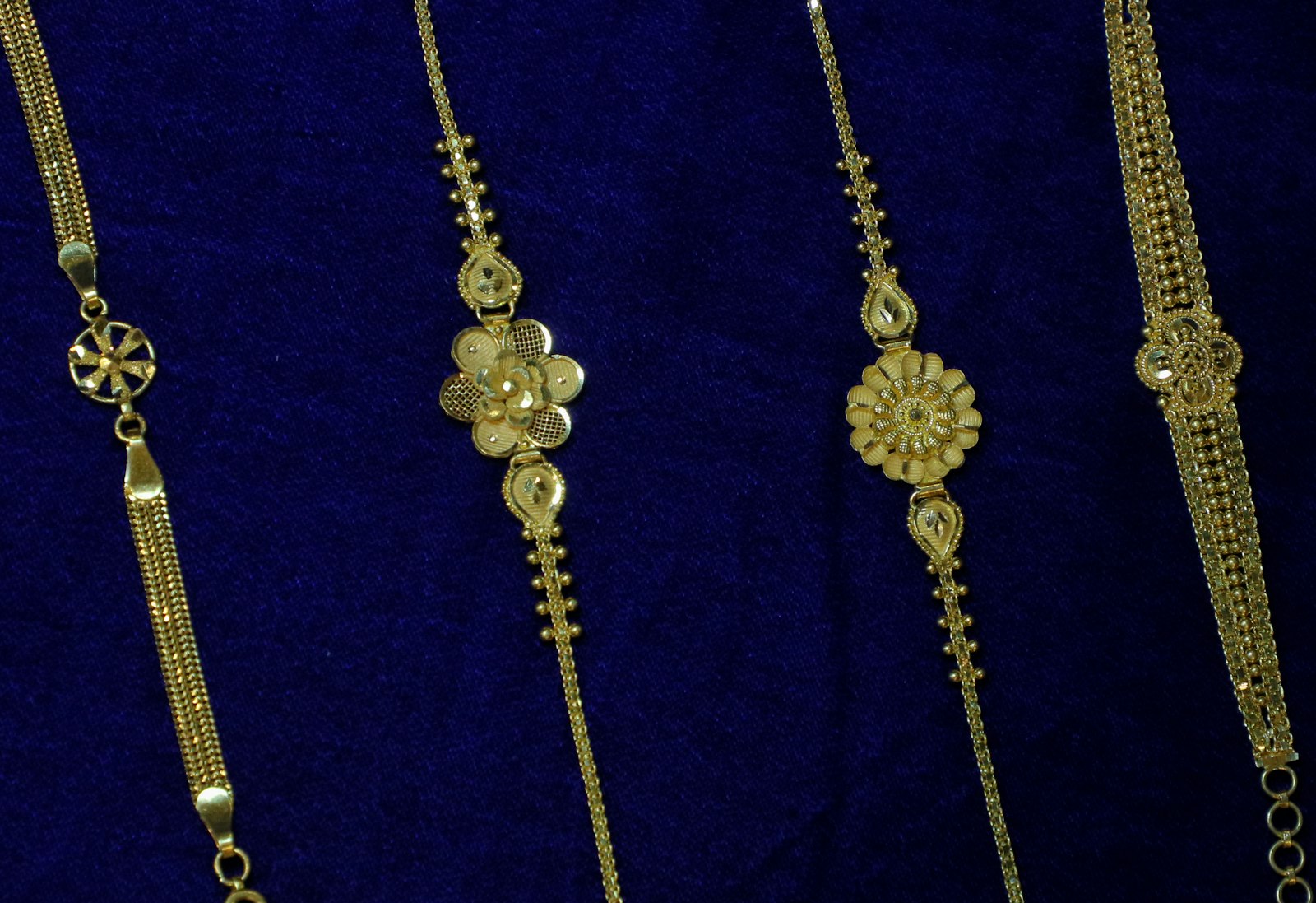 Delicate gold bracelets on blue velvet